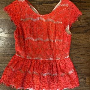 Salmon colored blouse with nude sheer underneath.